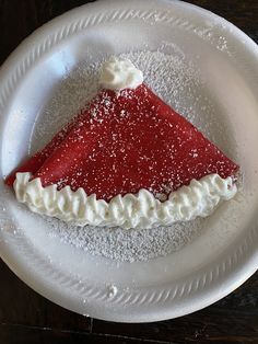 a piece of cake on a plate with powdered sugar and icing around it