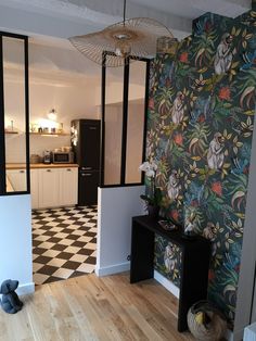 a kitchen with black and white checkered flooring next to a green wallpaper