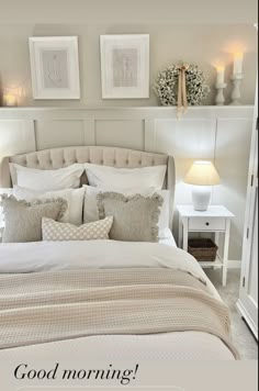 a bed with white sheets and pillows next to two pictures on the wall above it