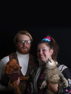 a man and woman are posing with their cats