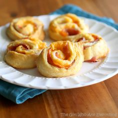 small pastries on a white plate sitting on a wooden table next to a blue napkin