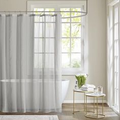 a bathroom with a tub, shower curtain and rug in front of the bathtub