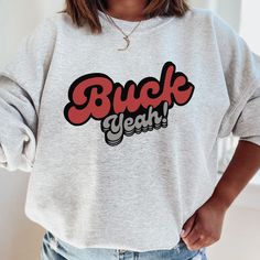 "Serve looks for Ohio State gameday in Columbus and around the OSU campus with this cute \"Buck Yeah\" crewneck designed for you to wear while rooting on the Ohio State Buckeyes! This design comes in a variety of colors, is super soft, and the perfect trendy sweatshirt to show support for your favorite college team. GO BUCKS! - Unisex sizing - 50/50 cotton and polyester blend  - Medium weight fabric (7.8 oz/yd² (264 g/m²) - Regular fit - Fleece inside - Tag-free neck label Care Instructions: Mac Casual Sweatshirt With Text Print For Fans, Casual Letter Print Sweatshirt For Fan Gear, Casual Game Day Sweatshirt With Text Print, Casual Sweatshirt With Text Print For Game Day, Casual Text Print Sweatshirt For Game Day, Casual Letter Print Sweatshirt For Game Day, Ohio State Sweatshirt, College Merch, Osu Buckeyes