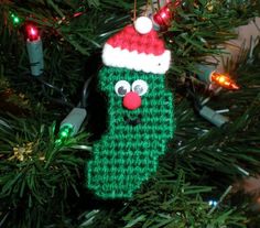 a knitted christmas stocking ornament hanging from a tree