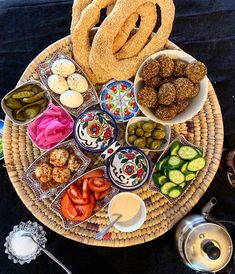 an assortment of food is arranged on a plate with dipping sauces and pretzels