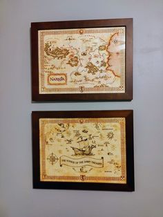 two framed maps hang on the wall above each other, one with a pirate map