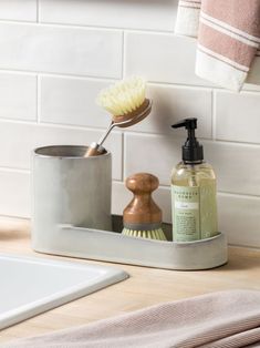 a soap dispenser and brush on a bathroom counter