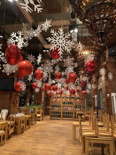 a restaurant decorated for christmas with snowflakes and red balls hanging from the ceiling