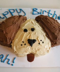 a cake shaped like a dog's head with chocolate frosting on the top