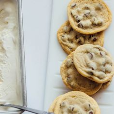 chocolate chip cookies and ice cream are on a white platter next to a pan