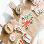 an assortment of wooden toys and decorations on a white table cloth covered with brown paper