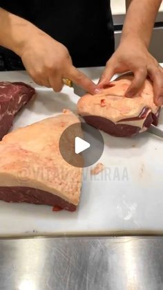 a person cutting up meat on top of a white counter next to another piece of meat