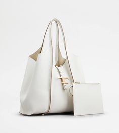 Shopping bag with flowing lines, crafted in elegant hammered leather with ribbing, branded metal T Timeless pendant accessory and double handles. Wide internal compartment with a removable pouch. Luxury White Bag With Palladium Hardware, Chic White Bag With Palladium Hardware, Elegant Tan Shoulder Bag With Removable Pouch, White Shoulder Bag With Palladium Hardware For Formal Occasions, Timeless White Bag With Handle Drop, Timeless White Top Handle Bag, Timeless Bags With Silver-tone Hardware, Timeless Tan Shoulder Bag With Silver-tone Hardware, White Top Handle Bag With Palladium Hardware