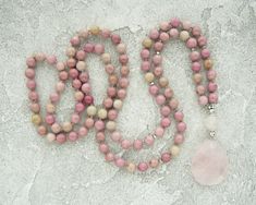 Rhodochrosite Mala Necklace for Women Pinck Beads Long Necklace Rose Quartz Mala Necklace Yoga Jewelry Yoga Gift for Mum Meditation Necklace-  8mm Natural Rhodochrosite Beads-  12mm Rose Quartz Guru Crystal Bead-  Rose Quartz Pendant-  Neylon Cord♥ ♥ ♥ ROSE QUARTZ ♥ ♥ ♥Rose Quartz Crystal is a quartz crystal that derives its name from its lovely rose pink color. These crystals come in a range of beautiful shades of pink.It is known as the 'love stone' as the message it emits is the strong vibrat Pink 8mm Beads Jewelry For Meditation, Pink Meditation Necklaces With Round Beads, Pink Round Beads Necklace For Meditation, Pink Round Beads Necklaces For Meditation, Pink Rose Quartz Necklace With 8mm Beads, Spiritual Pink Hand-strung Necklace, Pink Hand-strung Necklace As Gift, Pink Hand-strung Necklace For Gift, Hand-strung Pink Rose Quartz Necklace