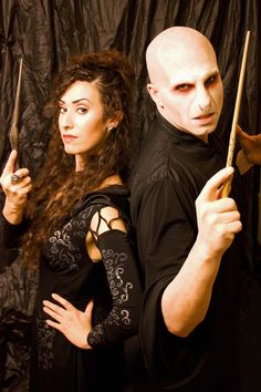 a man and woman dressed up as dracula and the girl in black is holding a knife