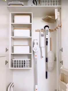 a white bathroom with lots of cleaning supplies on the shelves and in front of it is a toilet