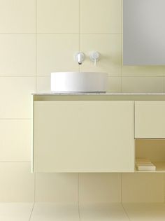 a bathroom with a sink, mirror and shelf on the wall next to tiled walls