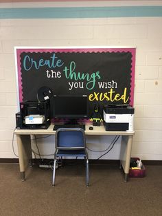 a desk with two computers on it in front of a sign that says create the things you wish excited