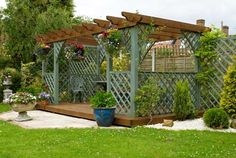 an outdoor garden area with potted plants and trellis