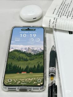 an iphone case sitting on top of a desk next to a pen