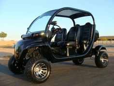 a black four passenger golf cart parked on the street