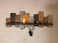 a candle is sitting on a shelf next to some keys