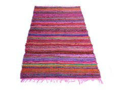 a multicolored rug with fringes on the top and bottom, against a white background