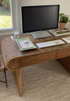 a computer monitor sitting on top of a wooden desk next to a keyboard and mouse