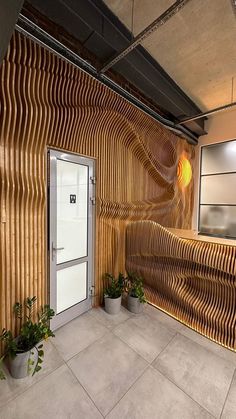 the entrance to an office building with wooden slats on the wall and potted plants