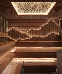 the inside of a sauna with wooden benches and decorative lighting on the ceiling above