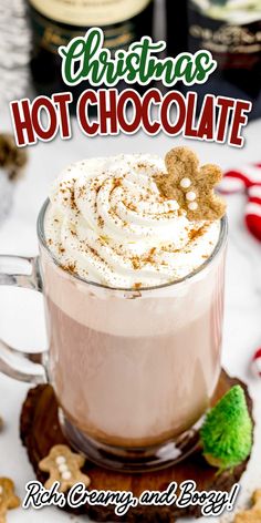 a hot chocolate drink with whipped cream and gingerbread on the rim in a glass mug