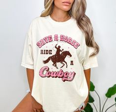 Save a horse ride a cowboy shirt. UNISEX SHIRT - 100% USA cotton - Pre-shrunk so no need to worry about shrinkage - Comfort Colors Brand - Heavyweight material for a more comfortable fit - Relaxed fit. Order a size up for a more baggy feel. Save A Horse Ride A Cowboy Shirt, Cowboy Pillows, Cowboy Pillow, Ride A Cowboy, Country Music Shirt, Rodeo Shirts, Country Music Shirts, Cowboy Shirt, Cowgirl Shirts