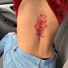 a woman's lower back tattoo with roses on her left side ribcage