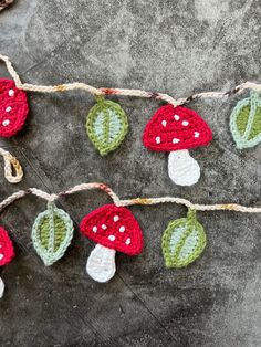 crocheted mushrooms and leaves are hanging on a string with twine to make them look like garlands