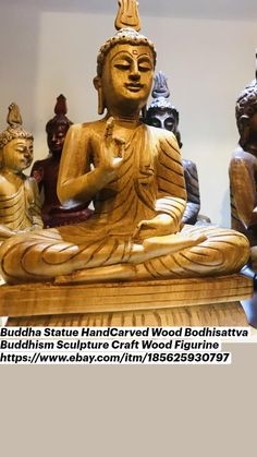 buddha statues sitting on top of a wooden table next to each other in a room