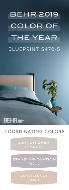 a bed with blue sheets and pillows next to a plant in a vase on top of it