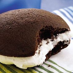 a chocolate ice cream sandwich on top of a green and white striped napkin with a bite taken out