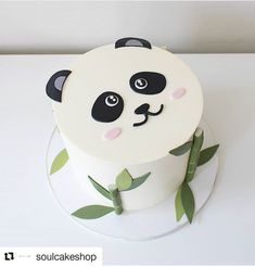 there is a cake with a panda face on it and green leaves around the edges