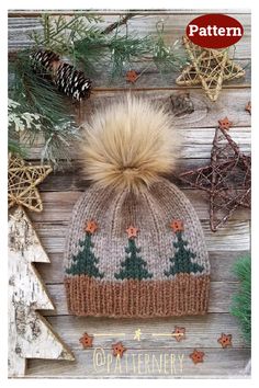 a knitted hat with pine trees and stars on the front, next to christmas decorations