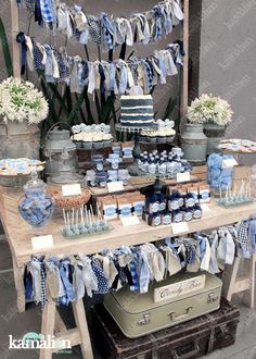 a table topped with lots of blue and white desserts on top of wooden crates