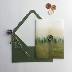 two pieces of paper with trees on them and one piece of wax stamp next to it