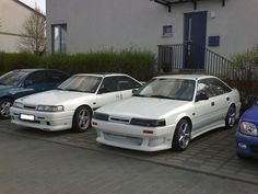 three white cars parked next to each other in front of a building