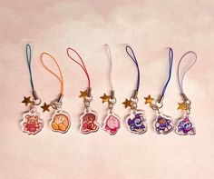 five key chains with different designs and colors on each one, all hanging from the same line