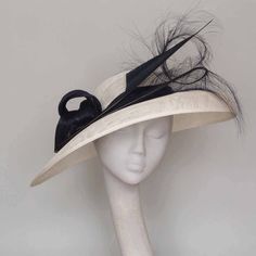 Make a statement in this elegant contemporary sweeping hat. Featuring white sinamay , wide brim, small crown with  navy silk abaca twists. Stunning burned ostrich feather and shaped navy feather.  This hat looks equally stunning with black trim. A hat for those who wish to remain noticeably unnoticed. Shipping to the USA  is by courier. For destinations not listed please ask for a shipping quotation. This hat can be made in many colours  please enquire. Kentucky Derby Hats For Women, Navy Fascinator, Special Occasion Hats, Mother Of The Bride Hats, Small Crown, Formal Hat, Hat Tea Party, Royal Ascot Hats, Ascot Hats