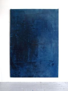 a blue painting on a white wall in an empty room with no one around it