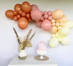 a table topped with a cake and balloons