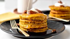 a stack of pancakes sitting on top of a black plate