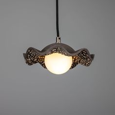 a light that is hanging from the ceiling in a room with gray walls and flooring