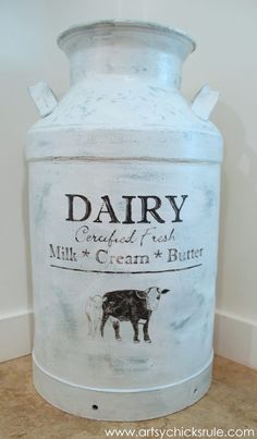 an old milk can with dairy labels painted on it