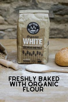 freshly baked bread with organic flour on a wooden table next to a bag of white bread